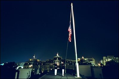 U.S. Marines lower the American flag flying over the White House to half staff at midnight Tuesday, September 10, 2002 to mark the anniversary of September 11. Pictured in the background is the Eisenhower Executive Office Building.