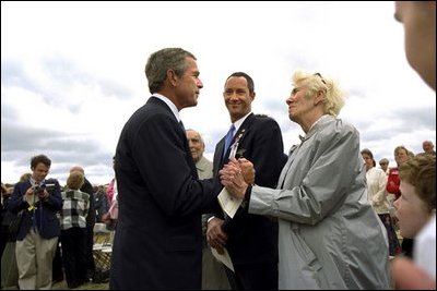 President George W. Bush talks to relatives of the victims from Flight 93 after laying a wreath at the crash site in Somerset County Pennsylvania on September 11, 2002.