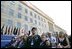 Sitting in front of the rebuilt section of the Pentagon, service personnel and families listen to President George W. Bush at the Pentagon Observance Wednesday, Sept. 11, 2002. "One year ago, men and women and children were killed here because they were Americans. And because this place is a symbol to the world of our country's might and resolve," said the President. "Today, we remember each life. We rededicate this proud symbol and we renew our commitment to win the war that began here."