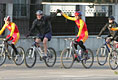 President George W. Bush raises the hand of a cyclist for China's Mountain Biking Team Sunday after completing a ride with the squad during his visit to Beijing.