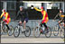 President George W. Bush raises the hand of a cyclist for China's Mountain Biking Team Sunday after completing a ride with the squad during his visit to Beijing.