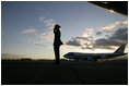 Air Force One sits on the tarmac at Osaka International Airport Wednesday, Nov. 16, 2005, as a military aide salutes the arrival of the President and Mrs. Bush.