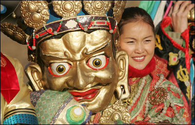 A participant in the cultural event for President and Mrs. Bush stands unmasked for photos Monday, Nov. 21, 2005, in Ikh Tenger, Mongolia. 