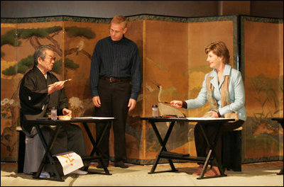 Mrs. Laura Bush receives instruction on calligraphy from Master Minoru Sawada, head calligraphy master of the Origin Arts Program, as Alex Kerr, author and Chairman of the Iori Co., looks on.