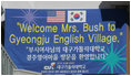 A banner welcomes the First Lady to Gyeongju English Village in Gyeongju, Korea, a village that dates back to the 1st century BC in the province of Gyeongsangdo.