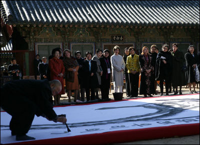 An artist paints calligraphy for the spouses of APEC leaders Friday, Nov. 18, 2005, during their visit to the Beomeosa Temple in Busan, Korea.