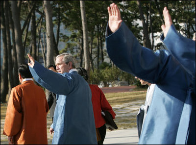 President George W. Bush waves to the crowd after joining his fellow APEC leaders for an official photograph Saturday, Nov. 19, 2005, at the Nurimaru APEC House in Busan, Korea.