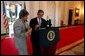 President George W. Bush discusses a speech with Karen Hughes in the Cross Hall of the White House June 6, 2002. White House photo by Eric Draper.