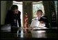 President George W. Bush White House Communications Director look over papers together in the Oval Office Oct. 8, 2001. White House photo by Eric Draper.