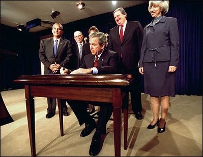 President George W. Bush signs H.R. 3908, the Reauthorization of the North American Wetlands Conservation Act in the Dwight D. Eisenhower Executive Office Building Dec. 2. Standing with the President for the signing are, from left to right, Rep. Robert Underwood (D-Guam), Rep. Wayne Gilchrest (R-MD), Sec. of Agriculture Ann Veneman, Sen. Bon Smith (R-NH) and Sec of Interior Gale Norton. The legislation matches federal funds with non-federal sources to promote public-private partnerships that conserve and restore the nation's wetlands.