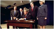 President George W. Bush signs H.R. 3908, the Reauthorization of the North American Wetlands Conservation Act in the Dwight D. Eisenhower Executive Office Building Dec. 2. Standing with the President for the signing are, from left to right, Rep. Robert Underwood (D-Guam), Rep. Wayne Gilchrest (R-MD), Sec. of Agriculture Ann Veneman, Sen. Bon Smith (R-NH) and Sec of Interior Gale Norton. The legislation matches federal funds with non-federal sources to promote public-private partnerships that conserve and restore the nation's wetlands.