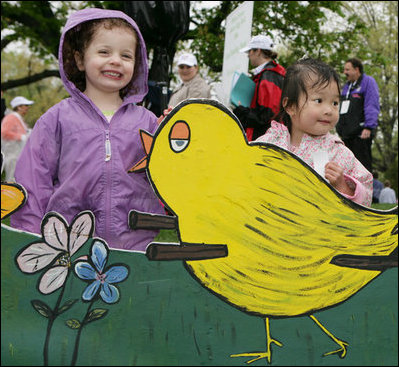 Children pose next to a decorative Easter display on the South Lawn of the White House during the 2006 White House Easter Egg Roll, Monday, April 17, 2006.