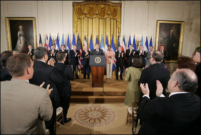 El Presidente George W. Bush acepta el aplauso de legisladores, funcionarios del gobierno e invitados el martes, 2 de agosto en el East Room de la Casa Blanca, en la ceremonia en la que se promulgó la CAFTA Implementation Act.