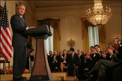 El Presidente George W. Bush recibe aplausos el viernes, 7 de octubre de 2005 en el East Room de la Casa Blanca mientras pronuncia unas palabras para conmemorar el Mes de la Hispanidad. El Presidente Bush también honró a las personas galardonadas con el premio al servicio voluntario del Presidente en el evento.