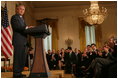 El Presidente George W. Bush recibe aplausos el viernes, 7 de octubre de 2005 en el East Room de la Casa Blanca mientras pronuncia unas palabras para conmemorar el Mes de la Hispanidad. El Presidente Bush también honró a las personas galardonadas con el premio al servicio voluntario del Presidente en el evento.