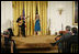 El Presidente George W. Bush, sentado al frente a la derecha, escucha la presentación de la cantante Ana Cristina y el guitarrista Marco Linares, el viernes, 6 de octubre de 2006, en el East Room de la Casa Blanca, durante la celebración del Mes de la Hispanidad. Foto por Paul Morse de la Casa Blanca