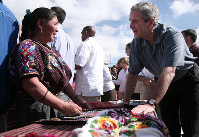 El Presidente George W. Bush conversa con un vendedor en la plaza de Santa Cruz Balanya el lunes, 12 de marzo de 2007, durante un recorrido por la aldea guatemalteca. Foto de Paul Morse de la Casa Blanca.