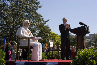 El presidente George W. Bush aplaude al Papa Benedicto XVI durante la ceremonia de bienvenida que se celebró en los Jardines de la Casa Blanca. Durante su discurso, el Santo Padre expresó que "Confío que los americanos encuentren en sus creencias religiosas una fuente preciosa de discernimiento y una inspiración para buscar un diálogo razonable, responsable y respetuosos en el esfuerzo de edificar una sociedad más humana y más libre".