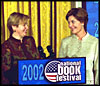 Laura Bush welcomes Ludmila Putina, wife of Vladimir Putin, President of the Russian Federation, to the Second Annual National Book Festival Saturday, October 12, 2002 in the East Room of the White House. Standing with the First Ladies on stage are, left to right, Native American poet Lucy Tapahoso, writer Mary Higgins Clark, Librarian of Congress James Billington, and NBA player Jerry Stackhouse.