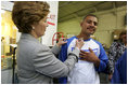 Laura Bush signs the shirt of a member of Homeboy Industries in Los Angeles April 27, 2005. Homeboy Industries is an job-training program that educates, trains and finds jobs for at-risk and gang-involved youth.