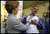 Laura Bush signs the shirt of a member of Homeboy Industries in Los Angeles April 27, 2005. Homeboy Industries is an job-training program that educates, trains and finds jobs for at-risk and gang-involved youth.