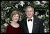 President George W. Bush and Laura Bush stand before the White House Christmas tree in the Blue Room of the White House. In keeping with this year's theme, "All Things Bright and Beautiful!" the Fraser fir is decorated with fresh white lilies.