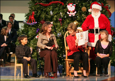 Accompanied by Neeko Scurlock, 6, left, and Samantha Melkonian, 12, Barbara Bush and Laura Bush take a peek at their dog, Miss Beazley, during a reading of "How the Grinch Stole Christmas," by Dr. Seuss at the Children's National Medical Center in Washington, D.C., Wednesday, Dec. 7, 2005.