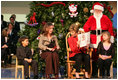 Accompanied by Neeko Scurlock, 6, left, and Samantha Melkonian, 12, Barbara Bush and Laura Bush take a peek at their dog, Miss Beazley, during a reading of "How the Grinch Stole Christmas," by Dr. Seuss at the Children's National Medical Center in Washington, D.C., Wednesday, Dec. 7, 2005.