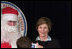 Laura Bush poses for a photo as she visits with children at the Naval and Marine Corps Reserve Center in Gulfport, Miss., Monday, Dec. 12, 2005, where she showed them a White House holiday video featuring the Bush's dogs "Barney and Miss Beazley."