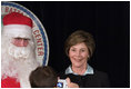 Laura Bush poses for a photo as she visits with children at the Naval and Marine Corps Reserve Center in Gulfport, Miss., Monday, Dec. 12, 2005, where she showed them a White House holiday video featuring the Bush's dogs "Barney and Miss Beazley."