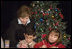 Laura Bush writes a note on a child's letter to his parent who is serving overseas, as she visits with children at the Naval and Marine Corps Reserve Center in Gulfport, Miss., Monday, Dec. 12, 2005, showing them a White House holiday video featuring the Bush's dogs "Barney and Miss Beazley."