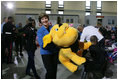 Mrs. Laura Bush helps carry a large stuffed animal to a toy distribution vehicle, Monday, Dec. 19, 2005, at the "Toys for Tots" collection center at the Naval District Washington Anacostia Annex in Washington, D.C., where she joined President George W. Bush in thanking the U.S. Marines for their charitable efforts.