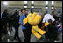 Mrs. Laura Bush helps carry a large stuffed animal to a toy distribution vehicle, Monday, Dec. 19, 2005, at the "Toys for Tots" collection center at the Naval District Washington Anacostia Annex in Washington, D.C., where she joined President George W. Bush in thanking the U.S. Marines for their charitable efforts.