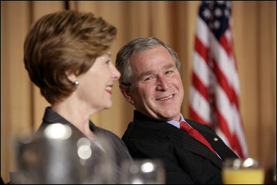 President George W. Bush and Laura Bush laugh during the National Prayer Breakfast in Washington, D.C., Thursday, Feb. 3, 2005.