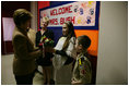 Hainerberg elementary students Montana Feix and Matt Bowlsby greet Laura Bush as she arrives to the school Tuesday, Feb. 22, 2005, in Wiesbaden, Germany. During her visit to the school Mrs. Bush heard a recital by the school chorus and talked with a group of fourth and fifth graders.