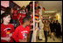 Laura Bush reaches for the hands of children waving U.S. and German flags as she passes them in the hallway of the Hainerberg Elementary School February, 22, 2005, in Wiesbaden, Germany.