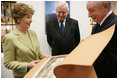 During the opening of University Library's "Info USA," Tibor Trgina, General Director of the library, shows Laura Bush books and artwork preserved at the library in Bratislava, Slovak Republic. Laura Bush was also joined by Slovak Republic's Minister of Culture Rudolf Chmel, center, during her visit to the library, Thursday, Feb. 24, 2005.