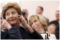 Laura Bush listens to translation headphones during a joint press conference with President George W. Bush and German Chancellor Gerhard Schroeder at the Electoral Palace in Mainz, Germany, Wednesday, Feb. 23, 2005. The Chancellor’s wife, Mrs. Schroeder-Koepf is seated next to Mrs. Bush.