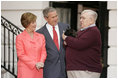 President George W. Bush and Laura Bush receive Miss Beazley, their new Scottish Terrier puppy, from breeder Bill Berry on the South Lawn of the White House Jan. 6, 2005. Miss Beazley is a birthday present from the President to Mrs. Bush. Beginning life at the White House in proper fashion, Miss Beazley's started her first day with a press conference.