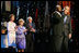 President George W. Bush puts his arm around Singer Bebe Winans as he sings 'God Bless America' during the 'Saluting Those Who Serve' event at the MCI Center in Washington, D.C., Tuesday, Jan. 18, 2005. Also pictured are, from left, Laura Bush, Lynne Cheney, and Vice President Dick Cheney.