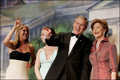 With his twin daughters Jenna, left, and Barbara by his side, President George W. Bush points out members of the audience to Laura Bush during a Black Tie and Boots Inaugural Ball in Washington, D.C., Wednesday, Jan. 19, 2005.