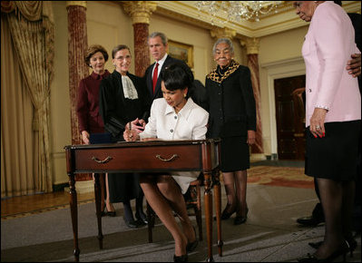 Secretary of State Dr. Condoleezza Rice signs official papers Friday, Jan. 28, 2005, after receiving the oath of office during her ceremonial swearing in at the Department of State. Watching on are, from left, Laura Bush, Justice Ruth Bader Ginsburg, President George W. Bush and an unidentified family member.