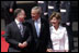 President George W. Bush and Laura Bush walk with Scotland's First Minister Jack McConnell during the playing of national anthems upon their arrival at Glasgow's Prestiwick Airport, July 6, 2005.