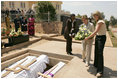 Laura Bush and daughter Jenna lay a wreath Thursday, July 14, 2005 at the Kigali Memorial Center-Gisozi Genocide Memorial in Kigali, Rwanda.