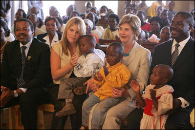 Laura Bush and daughter Jenna sit with children as they visit the Kagarama Church, Thursday, July 14, 2005, in Kigali, Rwanda.