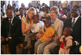 Laura Bush and daughter Jenna sit with children as they visit the Kagarama Church, Thursday, July 14, 2005, in Kigali, Rwanda.