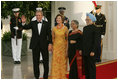 President George W. Bush and Laura Bush welcome India Prime Minister Dr. Manmohan Singh and Mrs. Gursharan Kaur, as they arrive for the official dinner at the White House, Monday, July 18, 2005.