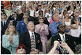 Laura Bush applauds as she folllows the launch of the Space Shuttle Discovery, Tuesday, July 26, 2005, at the Kennedy Space Center in Cape Canaveral, Florida. Mrs. Bush is joined by Florida Governor Jeb Bush, right, and NASA Astronaut Scott Altman, left.