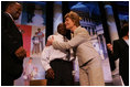 Laura Bush attends the Opening Session of the 2005 National Big Brothers Big Sisters Conference, June 9, 2005, at the Marriott Wardman Park Hotel. Washington, D.C. On-stage participants include: Vincent "Vinny" Thomas, Big Brother, left, ; and Parry Elliott, Little Brother, 13-years-old, being embraced by Mrs. Bush.