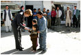 Laura Bush is greeted by youngsters outside a Kabul bakery during her visit Wednesday, March 30, 2005. The first lady presented White House red, white & blue kaleidoscopes to the children.